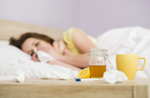 Foto: Syk dame i sengen med sitron og drikke på nattbordet