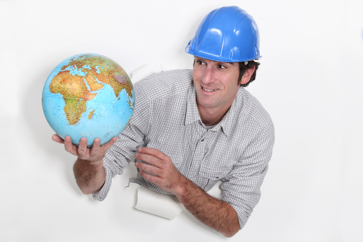 Foto: Mann med blå hjelm og en globus i hånden