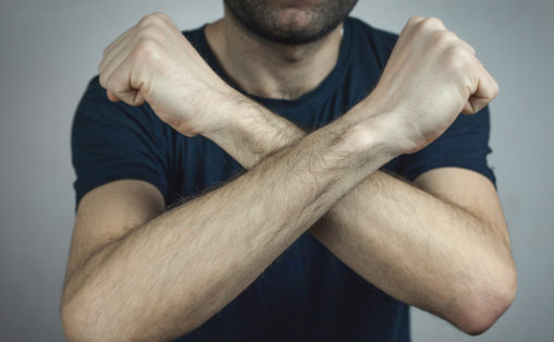 Foto: Muskuløs mann med knyttede never og armene i kryss