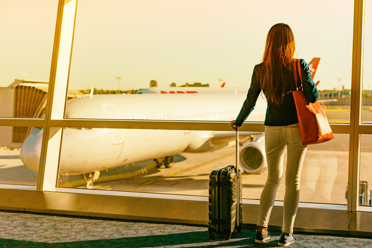 Foto: Dame med trillekoffert på flyplass