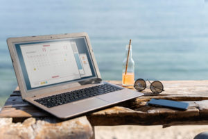 Foto: Jobbe under ferien med datamaskin på stranden.