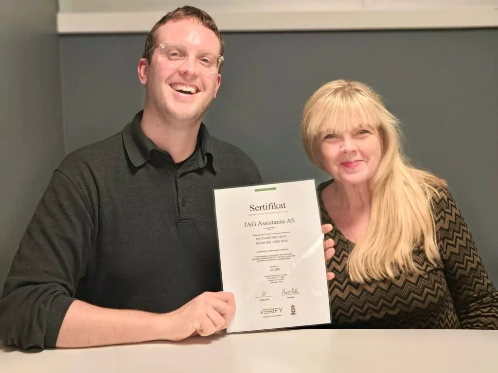 Foto av Cathrine Schumann. CEO/daglig leder i JAG Assistanse og Andreas Erichsen prosjektleder som holder ISO-sertifikatet for ISO9001 og ISO 14001.